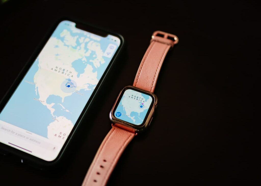 iPhone cu harta Americii de Nord lângă Apple Watch.